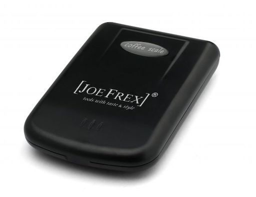 Die geschlossene digitale Kaffeewaage von Joe Frex vor weißem Hintergrund. Die Waage ist schwarz und hat eine gräulich weiße Bedrückung mit "Joe Frex" auf dem Decke.