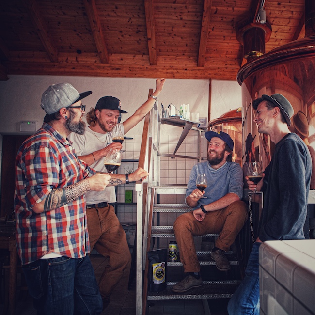 Wir sehen 4 Männer ausgelassen Craft Bier verkosten in der Brauerei von Bierol.