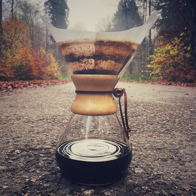 Eine Chemex Filterkaffee Karaffe mit fertigem schwarzen Kaffee steht auf einer Straße