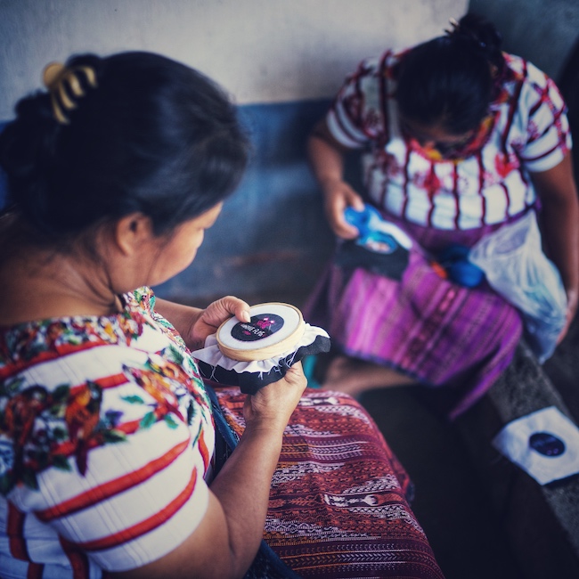 Zwei guatemaltekische Frauen sticken das White Flag Coffee Logo als Patch.