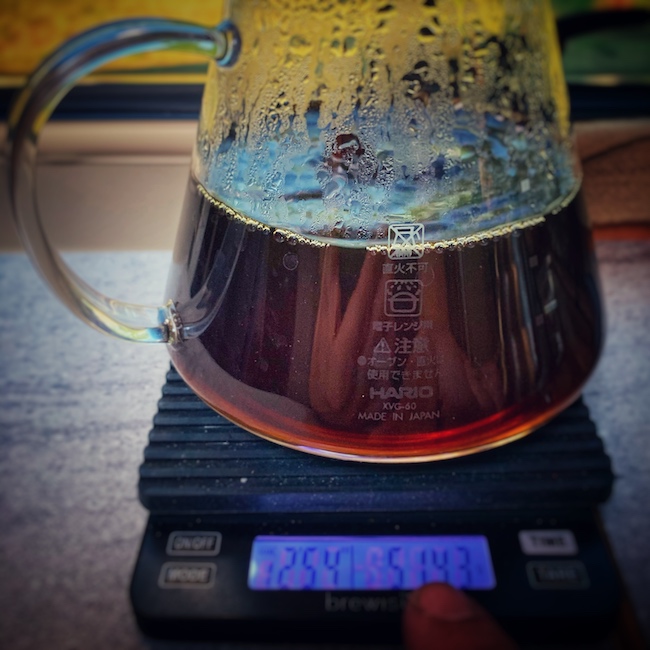Schwarzer Kaffee fließt in eine gläserne Servierkanne auf einer Brewista Kaffeewaage.