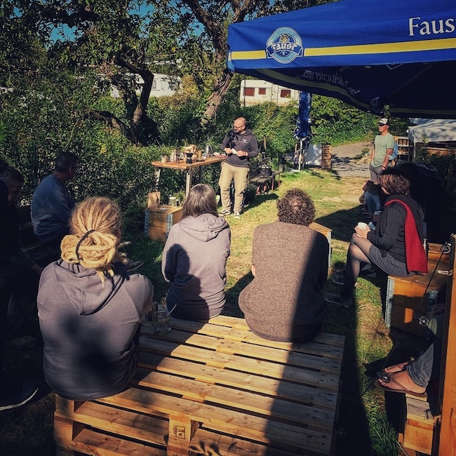 Beim "Guter Kaffee beim Camping Workshop" steht Horst von einfach mal Kaffee vor einer Gruppe Menschen erzählt spannendes