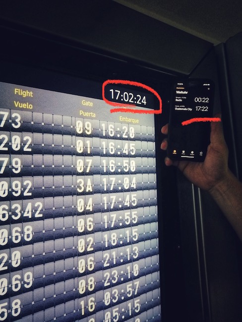 Auskunftstafel im Flughafen Guatemala hat eine Uhr, die 20 Minuten nach geht.